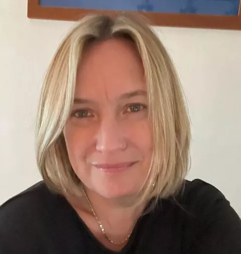 Woman in black jumper looking to camera