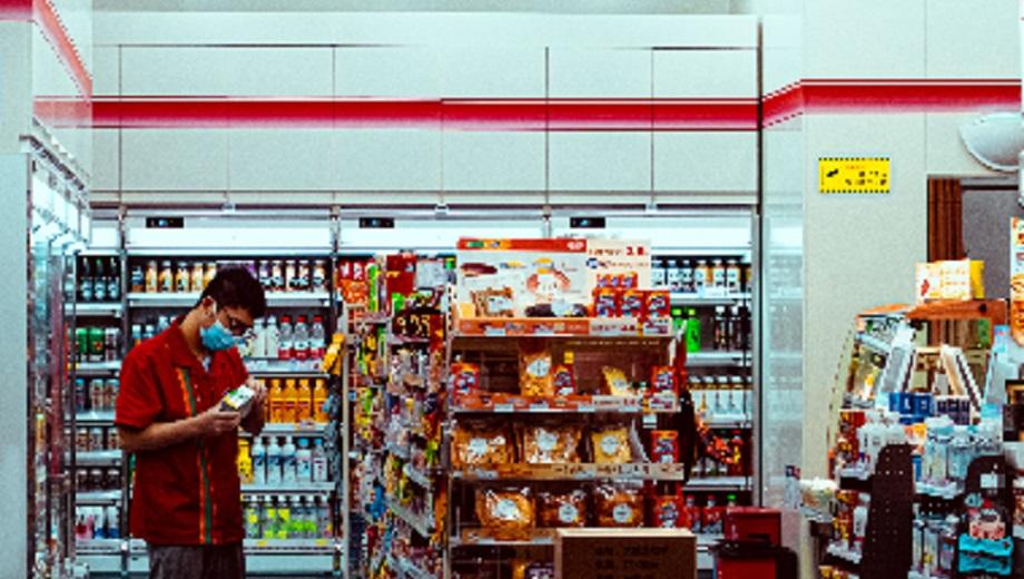 man in face covering at a convenience store credit kaihao zhao on unsplash