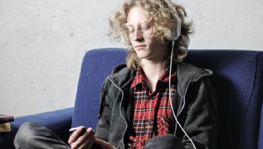 person on blue sofa using phone