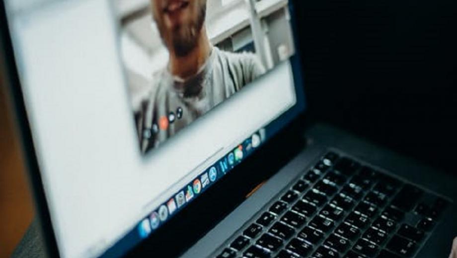 Man's face on laptop screen