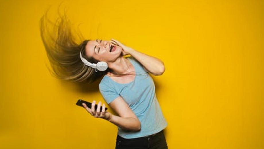 Woman dancing on her own wearing headphones